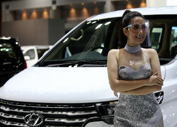 지난 14일(현지시간) 태국 방콕에서 열린 ‘제41회 방콕 국제 모터쇼’에서 모델이 투명 안면가리개를 쓰고 포즈를 취하고 있다. EPA 연합뉴스