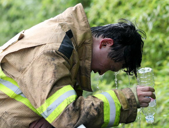 18일 10명의 부상자가 발생한 경기도 의왕시 고천동의 한 플라스틱 성형용기 제조공장 화재 현장에서 진화작업을 마친 소방관이 물로 열기를 식히고 있다. 2020.7.18  연합뉴스