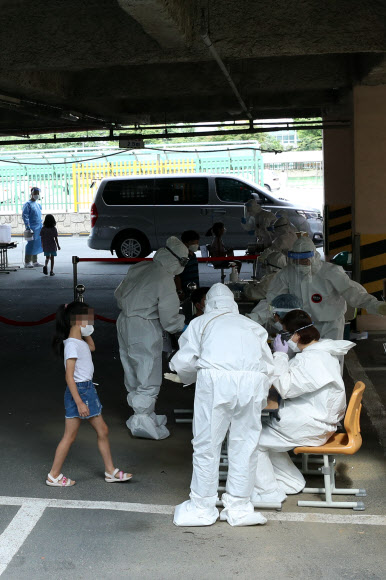 18일 오후 광주 서구 치평동 계수초등학교 주차장에 마련된 이동선별진료소에서 학생들이 신종 코로나바이러스 감염증(코로나19) 진단검사를 받고 있다. 방역 당국은 재학생인 남매가 코로나19 확진 판정을 받아 계수초교 전교생에 대해 전수검사를 하기로 했다. 2020.7.18  연합뉴스