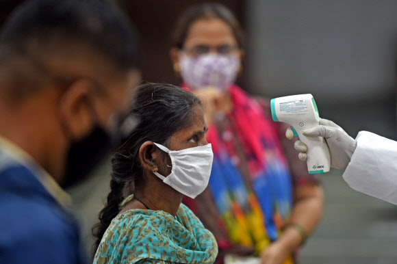 코로나19가 급증하고 있는 인도에서 한 여성이 체온검사를 받고 있다. AFP연합뉴스