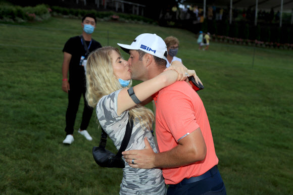 욘 람(오른쪽)이 20일 미국 오하이오주 더블린의 뮤어필드 빌리지 골프클럽에서 끝난 미국프로골프(PGA) 투어 메모리얼 토너먼트에서 우승한 뒤 아내와 함께 기쁨의 입맞춤을 하고 있다. 더블린 게티/AFP 연합뉴스