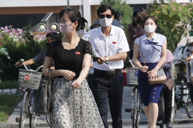 북한 주민들이 3일 마스크를 쓰고 려명 거리를 걸어가고 있다. 연합뉴스