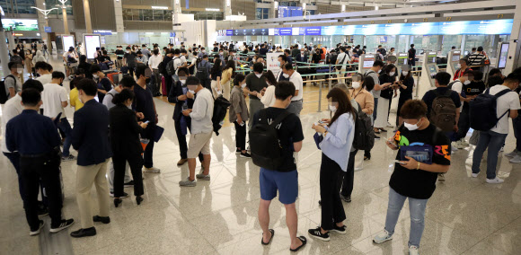 22일 오전 인천국제공항 1터미널 출국장에서 기업인들이 베트남행 전세기 탑승 수속을 위해 줄을 서 기다리고 있다. 이날 중소·중견기업 220개사, 대기업 17개사, 공기업 4개사 등 241개사의 571명을 시작으로 8월까지 총 1천500여명이 꽝닌성, 빈푹성 등으로 출국한다. 2020.7.22  연합뉴스