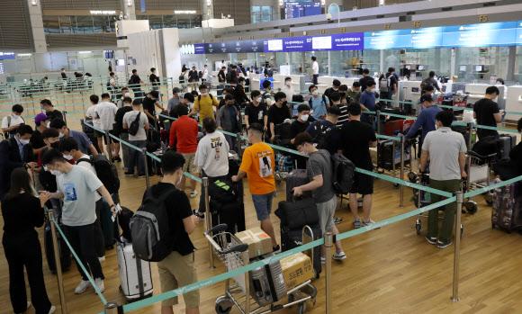 22일 오전 인천국제공항 1터미널 출국장에서 기업인들이 베트남행 전세기 탑승수속을 위해 줄을 서 기다리고 있다. 이날 중소·중견기업 220개사, 대기업 17개사, 공기업 4개사 등 241개사의 571명을 시작으로 8월까지 총 1천500여명이 꽝닌성, 빈푹성 등으로 출국한다. 2020.7.22  연합뉴스