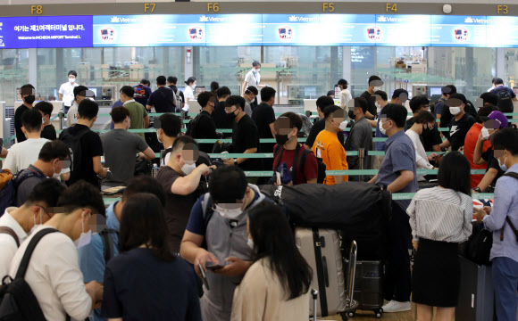 22일 오전 인천국제공항 1터미널 출국장에서 기업인들이 베트남행 전세기 탑승수속을 위해 줄을 서 기다리고 있다. 이날 중소·중견기업 220개사, 대기업 17개사, 공기업 4개사 등 241개사의 571명을 시작으로 8월까지 총 1천500여명이 꽝닌성, 빈푹성 등으로 출국한다. 2020.7.22  연합뉴스