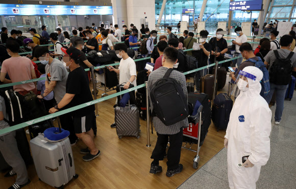 22일 오전 인천국제공항 1터미널 출국장에서 기업인들이 베트남행 전세기 탑승 수속을 위해 줄을 서 기다리고 있다. 이날 중소·중견기업 220개사, 대기업 17개사, 공기업 4개사 등 241개사의 571명을 시작으로 8월까지 총 1천500여명이 꽝닌성, 빈푹성 등으로 출국한다. 2020.7.22  연합뉴스