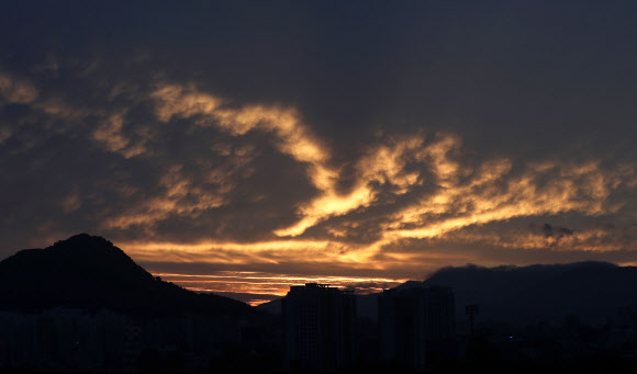 강원 내륙 대부분 지역에 폭염주의보가 이어지는 22일 오전 강원 춘천시 봉의산 너머 하늘이 일출로 붉게 물들고 있다. 기상청은 이날 춘천시의 낮 최고기온이 33도까지 오를 것으로 예보했다. 2020.7.22  연합뉴스