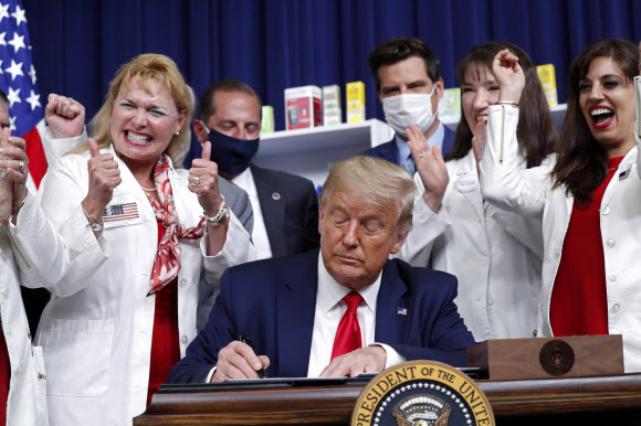 도널드 트럼프 대통령이 24일(현지시간) 백악관 남법원 강당에서 약값 인하 행정명령에 사인을 하고 있다. EPA 연합뉴스