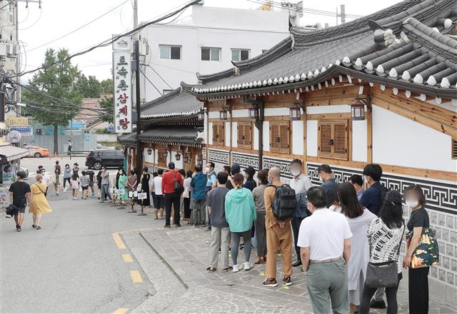 중복인 26일 서울 종로구의 한 삼계탕 전문점을 찾은 시민들이 줄지어 입장을 기다리고 있다. 2020.7.26 뉴스1