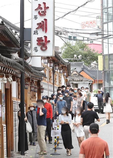 중복인 26일 서울 종로구의 한 삼계탕 전문점을 찾은 시민들이 줄지어 입장을 기다리고 있다. 2020.7.26 뉴스1