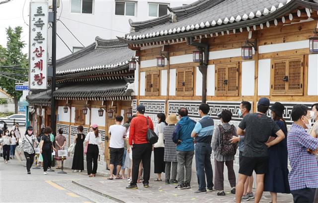 중복인 26일 서울 종로구의 한 삼계탕 전문점을 찾은 시민들이 줄지어 입장을 기다리고 있다. 2020.7.26 뉴스1
