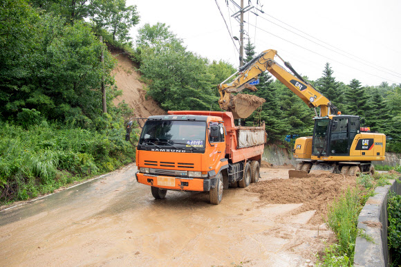 지난 23일부터 연사흘 쏟아진 폭우에 강원 고성지역에서도 크고 작은 피해가 속출한 가운데 26 간성읍 흘리지 역에서 도로로 쏟아져 내린 토사를 치우는 작업이 진행되고 있다. 2020.7.26 고성군청 제공