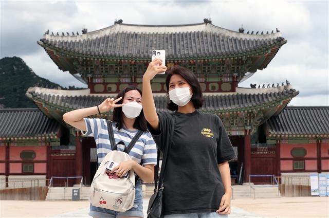 26일 서울 종로구 경복궁에서 시민들이 기념촬영을 하고 있다. 신종 코로나바이러스 감염증(코로나19)의 확산 방지를 위해 굳게 닫혔던 경복궁은 정부의 ‘수도권에 대한 강화된 방역 조치’가 완화됨에 따라 지난 22일 재개관했다. 2020.7.26 뉴스1