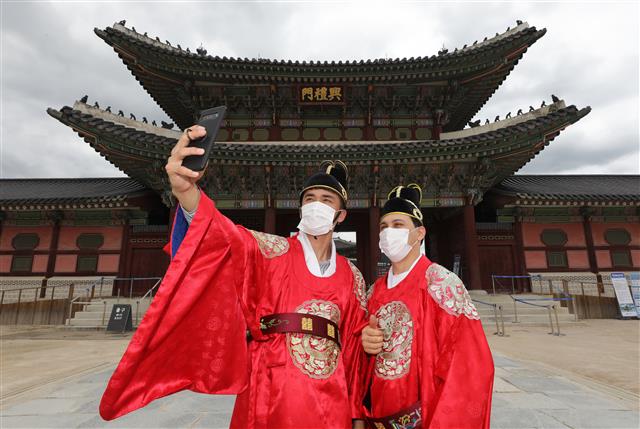 26일 서울 종로구 경복궁에서 임금 복장을 착용한 외국인들이 기념촬영을 하고 있다.신종 코로나바이러스 감염증(코로나19)의 확산 방지를 위해 굳게 닫혔던 경복궁은 정부의 ‘수도권에 대한 강화된 방역 조치’가 완화됨에 따라 지난 22일 재개관했다. 2020.7.26 뉴스1