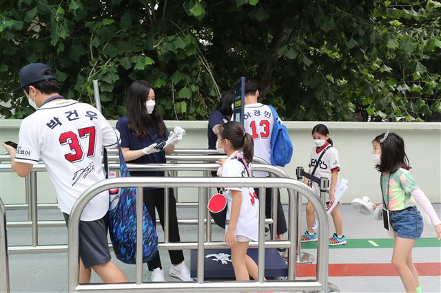 신종 코로나바이러스 감염증(코로나19) 사태로 닫혔던 관중석 출입구가 열렸다. 프로야구 관중 입장 첫 날인 26일 서울 잠실야구장을 찾은 시민들이 발열체크를 하고 있다. 문체부는 이날 진행되는 프로야구 경기부터 관중석 10%의 규모로 관중을 입장시키기로 했다. 2020.7.26 뉴스1