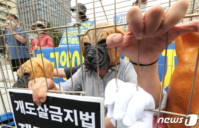 26일 오후 서울 광화문광장에서 열린 ‘중복, 개도살 금지법 제정을 촉구하는 퍼포먼스 기자회견’에서 비건 세상을 위한 시민모임(비시모) 관계자들이 철창 안에서 퍼포먼스를 하고 있다. 2020.7.26 뉴스1