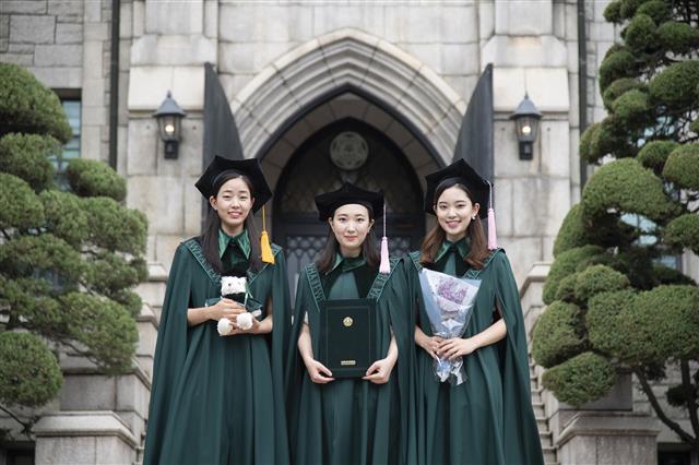 이화여자대학교(총장 김혜숙)는 134년 전통의 이화 고유 가치와 정체성을 담기 위해 지난 2월 학위복 디자인을 리뉴얼했다. 이화여대는 창립 이래 최초로 제작된 고유의 새 학위복을 오는 8월 졸업식을 앞두고 지난 7월 15일(수)부터 8월 6일(목)까지 예정으로 순차적 배부 진행 중이다.  이화여대는 지난 2월 개최 예정이었으나 코로나19로 연기된 2019학년도 전기 졸업식과 후기 졸업식을 통합하여 올해 8월 28일(금) 온라인 개최할 예정이다.  사진은 새 학위복을 입고 졸업사진을 촬영하는 이화여대 학생들의 모습.  2020.7.27 이화여대 제공