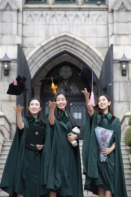 이화여자대학교(총장 김혜숙)는 134년 전통의 이화 고유 가치와 정체성을 담기 위해 지난 2월 학위복 디자인을 리뉴얼했다. 이화여대는 창립 이래 최초로 제작된 고유의 새 학위복을 오는 8월 졸업식을 앞두고 지난 7월 15일(수)부터 8월 6일(목)까지 예정으로 순차적 배부 진행 중이다.  이화여대는 지난 2월 개최 예정이었으나 코로나19로 연기된 2019학년도 전기 졸업식과 후기 졸업식을 통합하여 올해 8월 28일(금) 온라인 개최할 예정이다.  사진은 새 학위복을 입고 졸업사진을 촬영하는 이화여대 학생들의 모습. 2020.7.27 이화여대 제공