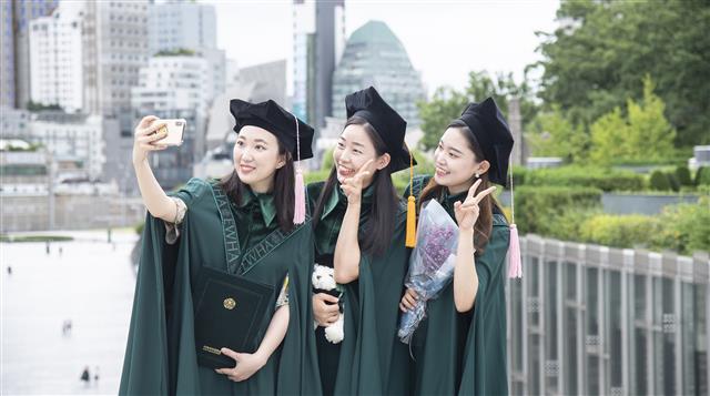 이화여자대학교(총장 김혜숙)는 134년 전통의 이화 고유 가치와 정체성을 담기 위해 지난 2월 학위복 디자인을 리뉴얼했다. 이화여대는 창립 이래 최초로 제작된 고유의 새 학위복을 오는 8월 졸업식을 앞두고 지난 7월 15일(수)부터 8월 6일(목)까지 예정으로 순차적 배부 진행 중이다.  이화여대는 지난 2월 개최 예정이었으나 코로나19로 연기된 2019학년도 전기 졸업식과 후기 졸업식을 통합하여 올해 8월 28일(금) 온라인 개최할 예정이다.  사진은 새 학위복을 입고 졸업사진을 촬영하는 이화여대 학생들의 모습. 2020.7.27 이화여대 제공