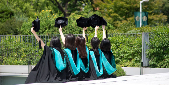 이화여자대학교가 오는 8월 전?후기 학위수여식을 앞두고 134년 만에 디자인이 교체된 새 학위복을 선보였다. 사진은 졸업을 맞은 이화여대 학생들이 새 학위복을 입고 졸업사진 촬영하는 모습. 2020.7.27 이화여자대학교 제공