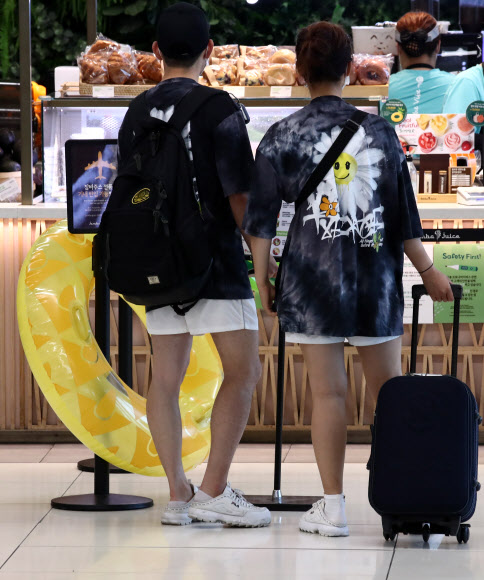 본격적인 여름 휴가철을 맞아 27일 오전 서울 강서구 김포공항 국내선 터미널에서 이용객들이 비행기 출발 시간을 기다리며 식음료를 고르고 있다. 2020.7.27  연합뉴스