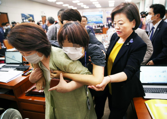 정의당 심상정 대표가 28일 서울 여의도 국회에서 열린 국토위원회 전체회의에서 쓰러진 보좌관을 업고 회의장을 나서고 있다. 2020.7.28  연합뉴스