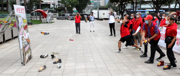 30일 서울시청 앞에서 열린 전국철거민협의회 시위에서 참석자들이 서울시에 철거민정책토론회 주최를 요구하며 신발 투척 퍼포먼스를 하고 있다. 2020.7.30  연합뉴스
