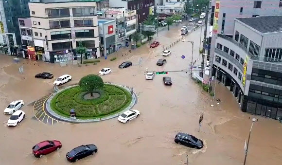 폭우가 쏟아진 3일 충남 아산시 온양관광호텔 앞 로터리가 침수돼 차량이 물길을 헤치며 가고 있다. 2020.8.3 연합뉴스