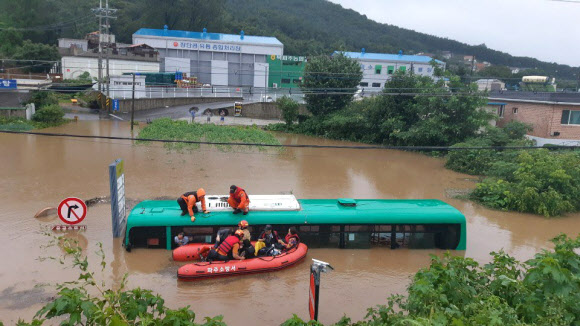 물에 잠긴 버스  6일 오전 경기 파주시의 한 도로에서 시내버스가 물에 잠겨 구조 대원들이 승객들을 구조하고 있다.2020.8.6<br>파주소방서 제공