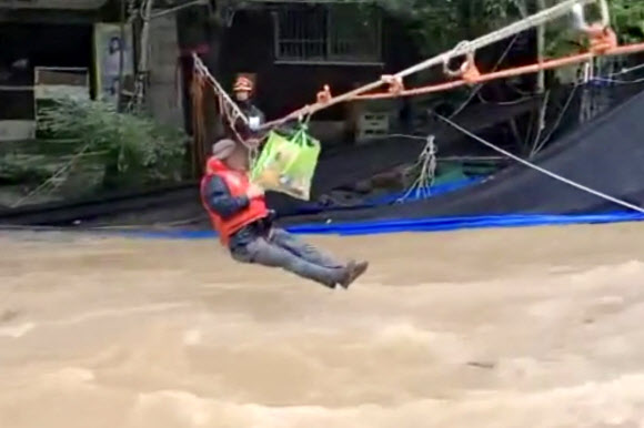 지난 8일 오후 5시 37분께 전남 담양군 월산면 한 펜션에서 출입구 앞에 물이 차올라 투숙객과 펜션 관계자들이 로프를 타고 소방대원들에 의해 구조되고 있다. 2020.8.9  전남소방본부 제공