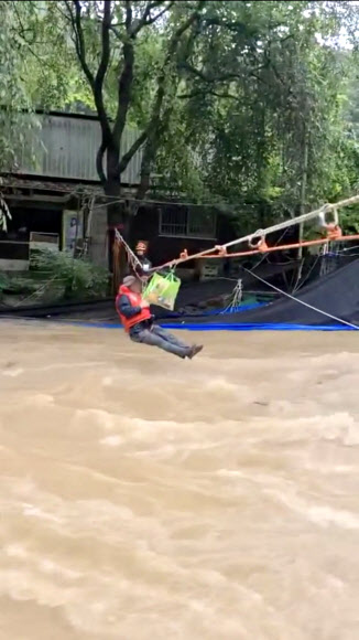 지난 8일 오후 5시 37분께 전남 담양군 월산면 한 펜션에서 출입구 앞에 물이 차올라 투숙객과 펜션 관계자들이 로프를 타고 소방대원들에 의해 구조되고 있다. 2020.8.9  전남소방본부 제공