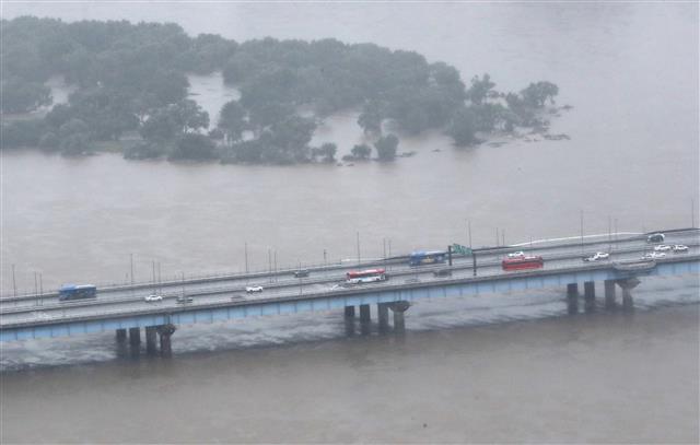 중부지방 집중호우가 계속된 9일 오후 한강물이 차오른 마포대교 위를 차량들이 달리고 있다. 2020.8.9 뉴스1