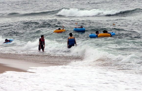장맛비가 이어진 9일 오후 강원 강릉시 경포 해수욕장에서 피서객들이 물놀이하고 있다. 2020.8.9  연합뉴스