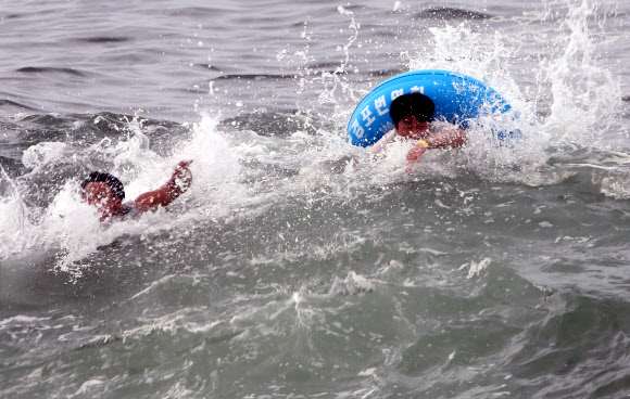 장맛비가 이어진 9일 오후 강원 강릉시 경포 해수욕장에서 피서객들이 물놀이를 하고 있다. 2020.8.9  연합뉴스