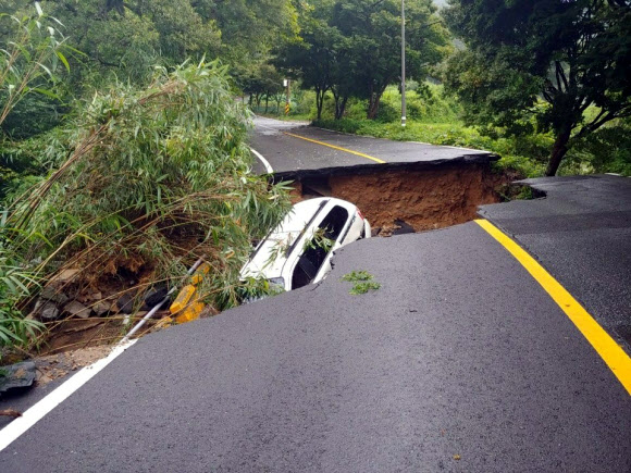 광주 북구 화암동 무등산국립공원 내 도로가 8일 폭우로 함몰돼 승용차 한 대가 추락했다. 담당 지방자치단체는 지반의 흙이 유실되면서 사고가 난 것으로 보고 복구작업을 벌이고 있다. 2020.8.9  광주 북구 제공