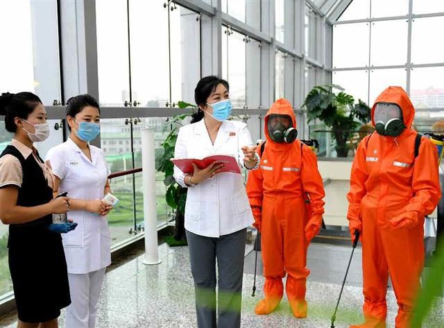 북한 노동당 기관지 노동신문은 10일 각 백화점 내 신종 코로나바이러스 감염증(코로나19) 방역 규정 준수를 강조했다. 신문은 “마스크를 착용한 상태에서 봉사를 하며 손 소독을 규정대로 진행하도록 요구성을 높이고 있다”라며 “위생담당 성원들은 손님들에 대한 체온 재기와 손 소독을 철저히 진행하고 있다”라고 전했다. 사진은 대성백화점에서 방역사업을 진행 중인 노동자들의 모습. 평양 노동신문=뉴스1