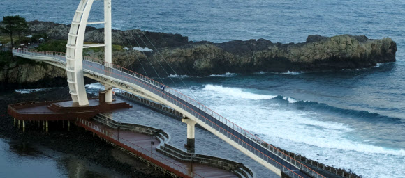 제5호 태풍 ‘장미’가 제주도를 향해 북상 중인 10일 오전 우산을 쓴 한 시민이 제주 서귀포항 새연교를 산책하고 있다. 2020.8.10  연합뉴스
