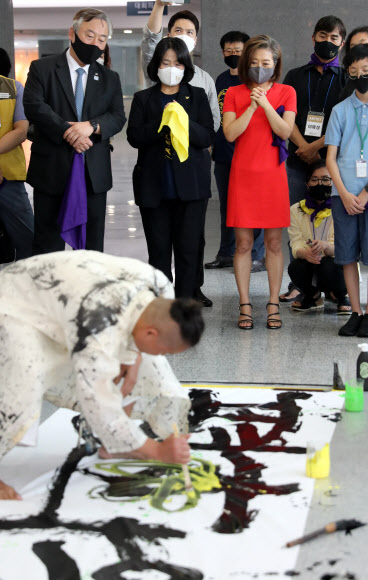 더불어민주당 윤미향 의원이 10일 오전 서울 여의도 국회 의원회관에서 열린 일본군‘위안부’피해자 기림의 날 전시 ‘뚜벅뚜벅’ 개막행사에서 캘리그라피 퍼포먼스를 지켜보고 있다.  2020.8.10  연합뉴스