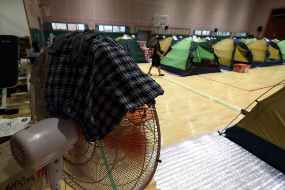 10일 전남 구례군 구례여자중학교 강당에 마련된 이재민 대피소의 선풍기에 옷과 양말 빨래가 널려 있다. 2020.8.10  연합뉴스
