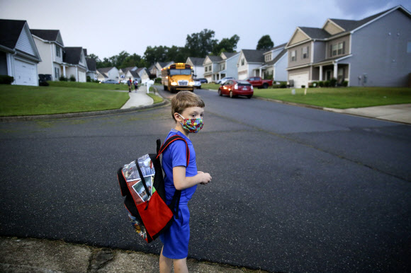 지난 3일(현지시간) 미국 댈러스에서 공립학교들이 문을 연 가운데 한 아이가 스쿨버스를 기다리고 있다. AP통신