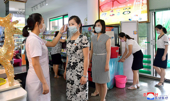 북한에서 신종 코로나바이러스 감염증(코로나19) 위생방역사업을 강화해나가고 있다고 조선중앙통신이 10일 보도했다. 사진은 평양의 한 안경점에서 시민들이 발열체크를 하는 모습. 2020.8.10 평양 조선중앙통신=연합뉴스