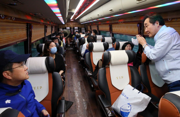 더불어민주당이 전국 수해 현장 봉사활동에 나선 11일 국회에서 이낙연(오른쪽), 박성준, 고민정 의원 등이 충북 음성으로 떠나는 버스 안에서 이야기를 나누고 있다.  2020.8.11  연합뉴스