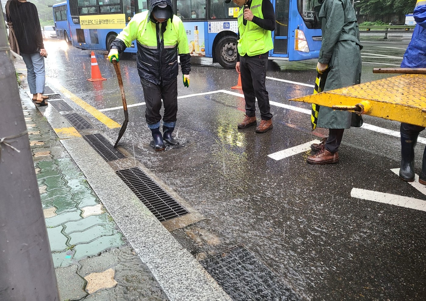 지난 10일 서울 성북구 정릉로의 한 버스전용차로에 생긴 포트홀을 아스콘으로 덮는 작업을 하고 있는 모습. 원래대로는 물을 걷어내고 작업을 해야 하지만, 끊임없이 내리는 비에 일단 사고를 막기 위해 포트홀을 막는 임시 작업을 하고 있다.<br>이근아 기자 leegeunah@seoul.co.kr