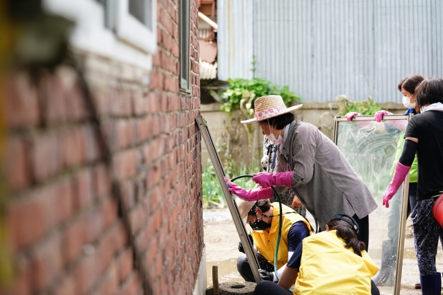 문재인 대통령의 부인 김정숙 여사가 12일 강원 철원군 동송읍 이길리 마을에서 수해 복구 봉사활동을 하고 있다/청와대 제공