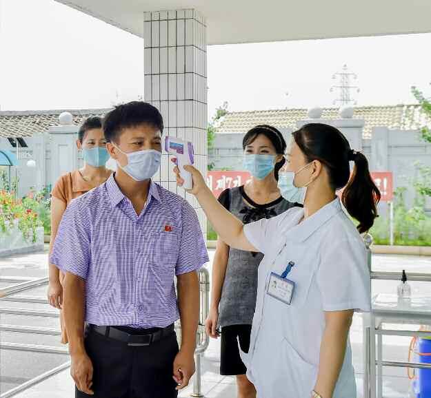 북한 노동당 기관지 노동신문은 13일 신종 코로나바이러스 감염증(코로나10) 관련 “최대로 각성 분발하여 비상방역 사업에 계속 큰 힘을 넣자”라고 강조했다. 사진은 평양치과위생용품공장 입구에서 체온을 측정하는 모습.  평양 노동신문=뉴스1