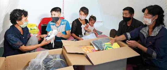 수해를 입은 황해북도 은파군 대청리 주민들이 자신 명의의 예비양곡과 필수 물자를 보내준 김정은 국무위원장에게 감사의 편지를 전했다고 노동당 기관지 노동신문이 13일 보도했다. 김 위원장은 지난 6~7일 이 곳을 찾았으며, 9일 양곡이 전달된 데 이어 10일에는 당 간부의 가족들을 통해 필수 물자가 지원됐다. 사진은 지원 물자를 받고 있는 지역 주민들. 평양 노동신문=뉴스1