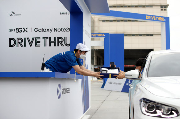13일 오전 서울 성동구 비트플렉스 5층 야외 주차장에서 SK텔레콤이 개최한 갤럭시 노트20 5G 드라이브 스루 행사에서 고객이 드라이브 스루 방식으로 갤럭시 노트20을 받고 있다. 2020.8.13  연합뉴스