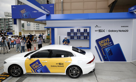 13일 오전 서울 성동구 비트플렉스 5층 야외 주차장에서 SK텔레콤이 개최한 갤럭시 노트20 5G 드라이브 스루 행사에서 고객이 드라이브 스루 방식으로 갤럭시 노트20을 받고 있다. 2020.8.13  연합뉴스
