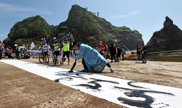 13일 오전 경상북도 울릉군 독도에서 독도사랑예술인연합회 김동욱 서예가가 서예 퍼포먼스를 하고 있다. 2020.8.13  연합뉴스