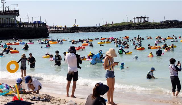 제주 지역 낮 최고기온이 36.1도까지 오르며 폭염경보가 발효 중인 13일 오전 제주시 함덕해수욕장에서 피서객들이 해수욕을 즐기고 있다.2020.8.13 뉴스1